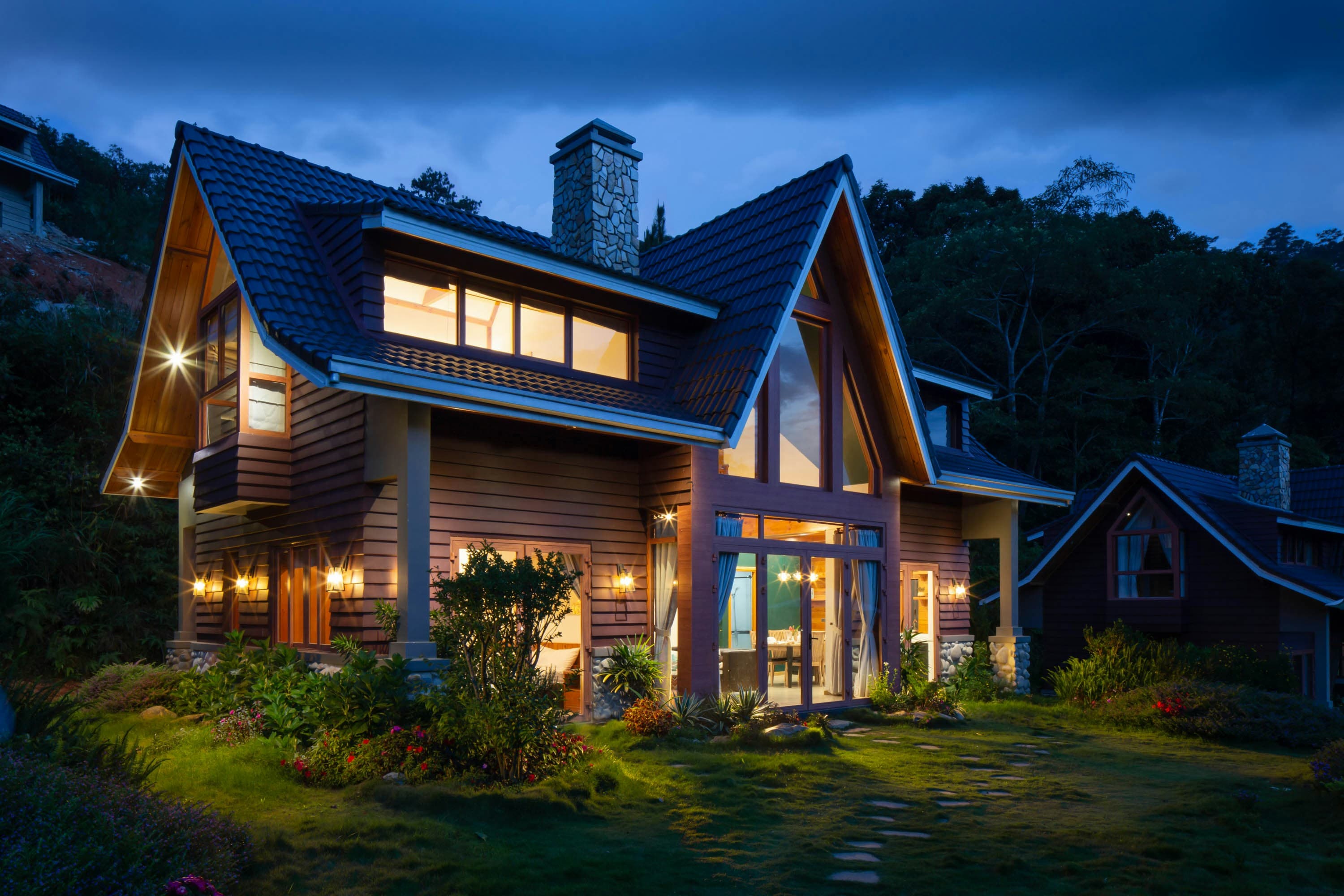 Modern hillside residence glowing warmly against the evening